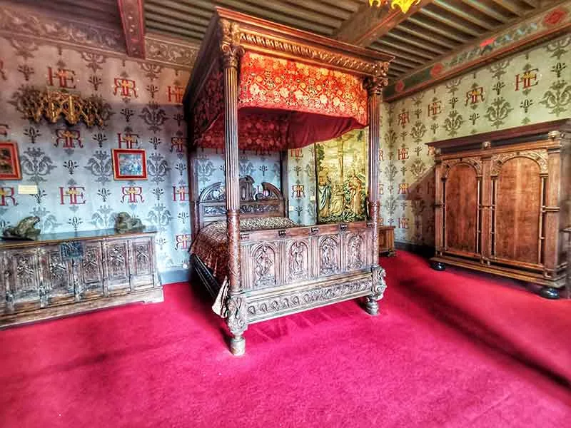 Het bed van een slaapkamer in het Château de Rochelambert in de Haute-Loire