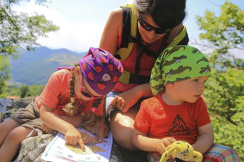 A family looks at the map of an easy hike in Haute-Loire, Auvergne