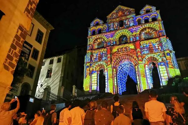 La multitud contempla la catedral de Notre-Dame-du-Puy iluminada por el Puy en Lumières