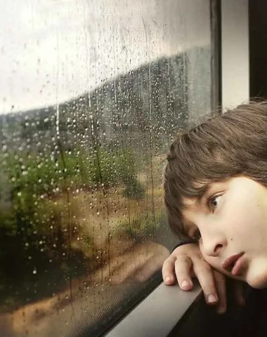 Een kind kijkt naar de regen door het treinraam in de Haute-Loire