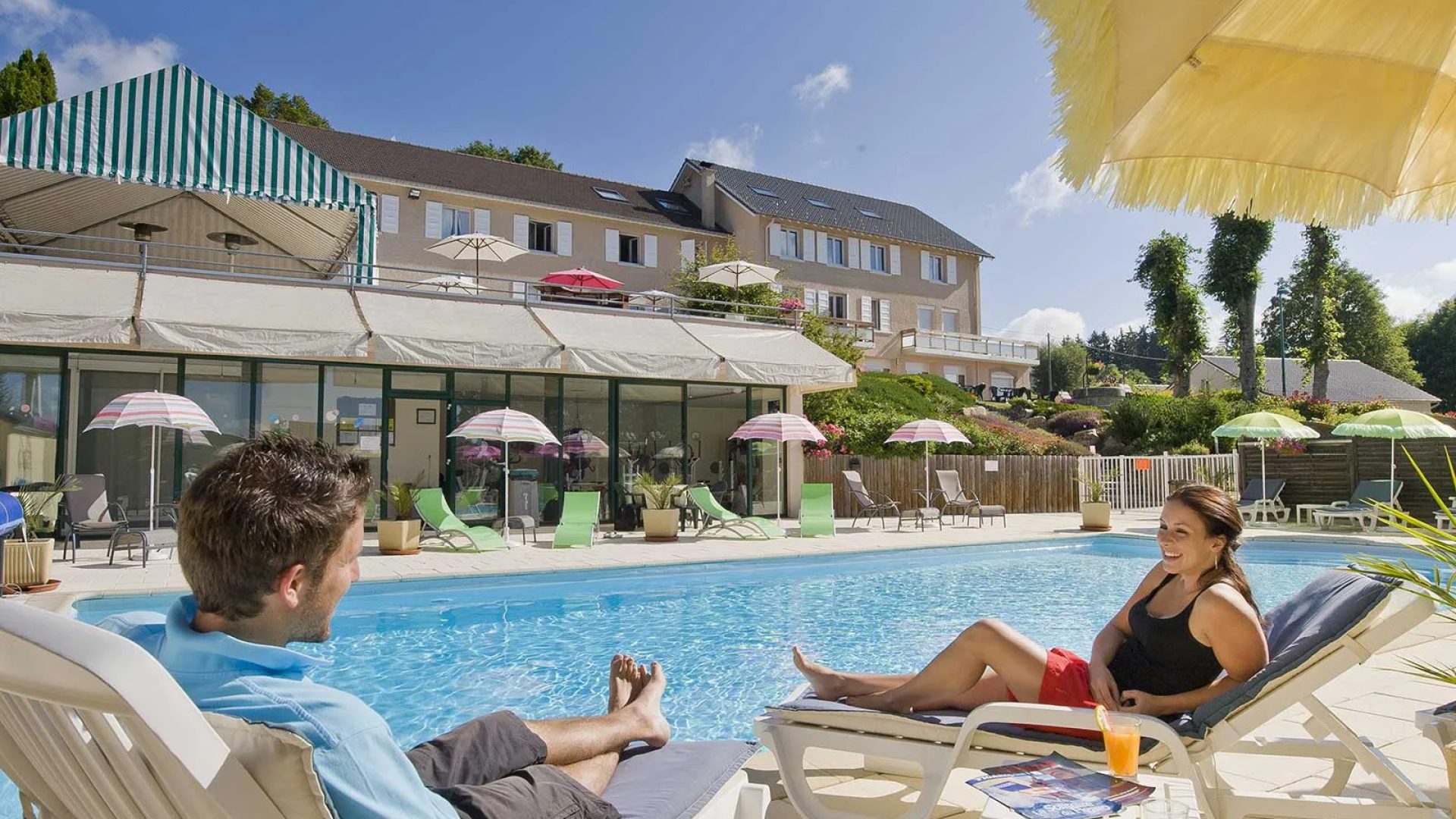 A couple relaxes by the outdoor swimming pool of the Bel Horizon hotel in Chambon-sur-Lignon in Haute-Loire