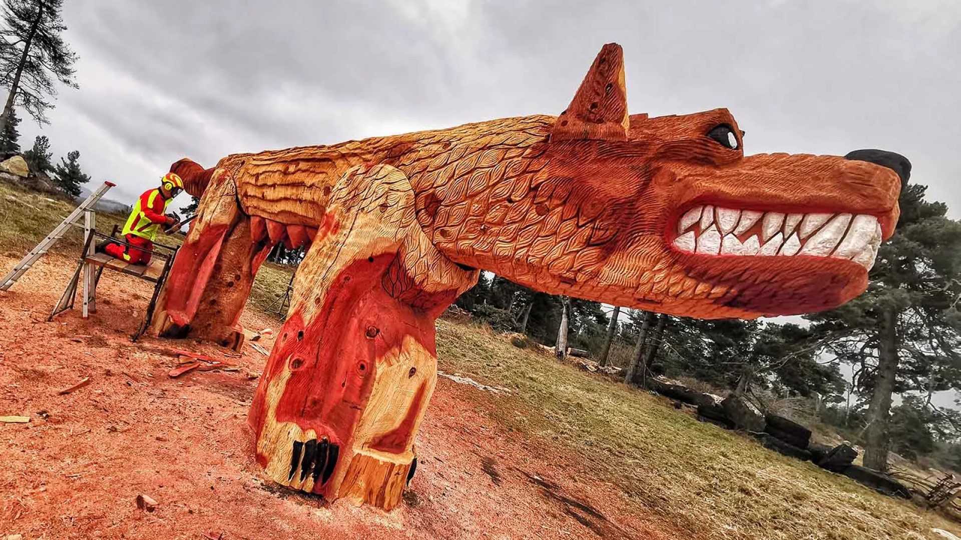 In Saugues in der Haute-Loire schnitzt ein Mensch einen riesigen Wolf (das Tier von Gévaudan) in Holz