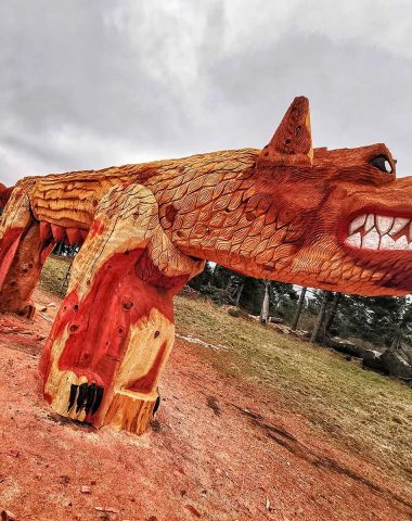 Een persoon snijdt een gigantische wolf (het beest van Gevaudan) in hout in Saugues in Haute-Loire