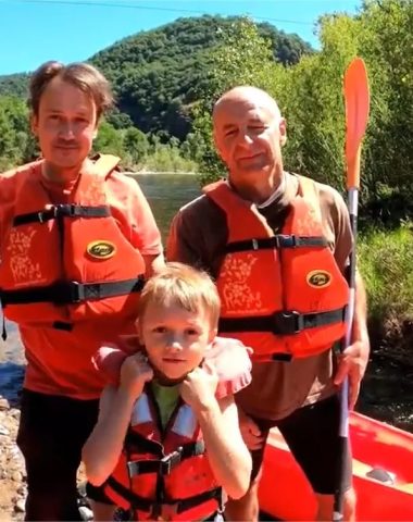 Two men and a child stand ready to go kayaking in Haute-Loire, Auvergne