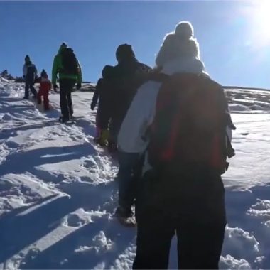Un gruppo cammina sulla neve con le racchette da neve sotto il sole dell'Alta Loira, in Alvernia