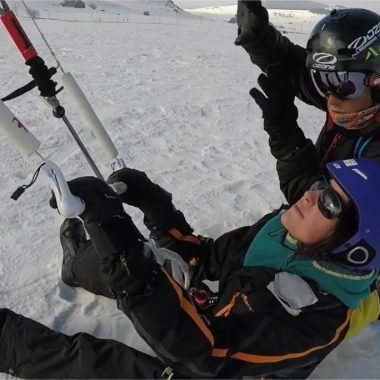 Ein Snowkite-Lehrer bringt einer Frau im Schnee in Haute-Loire, Auvergne, den Umgang mit ihrem Kite bei
