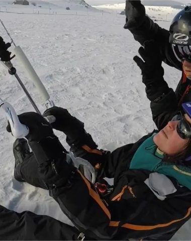 Ein Snowkite-Lehrer bringt einer Frau im Schnee in Haute-Loire, Auvergne, den Umgang mit ihrem Kite bei