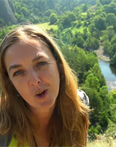 Eine Frau spricht aus niedriger Perspektive mit dem Fluss und dem Wald in Haute-Loire, Auvergne