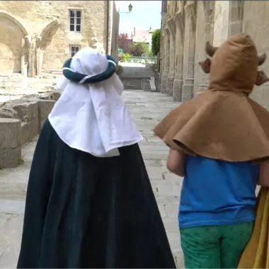 Bambini in costume camminano attraverso i terreni dell'Abbaye de la Chaise-Dieu in Haute-Loire, Auvergne