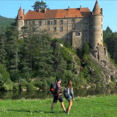 Ein Paar wandert und geht an einem Schloss in der Haute-Loire in der Auvergne vorbei