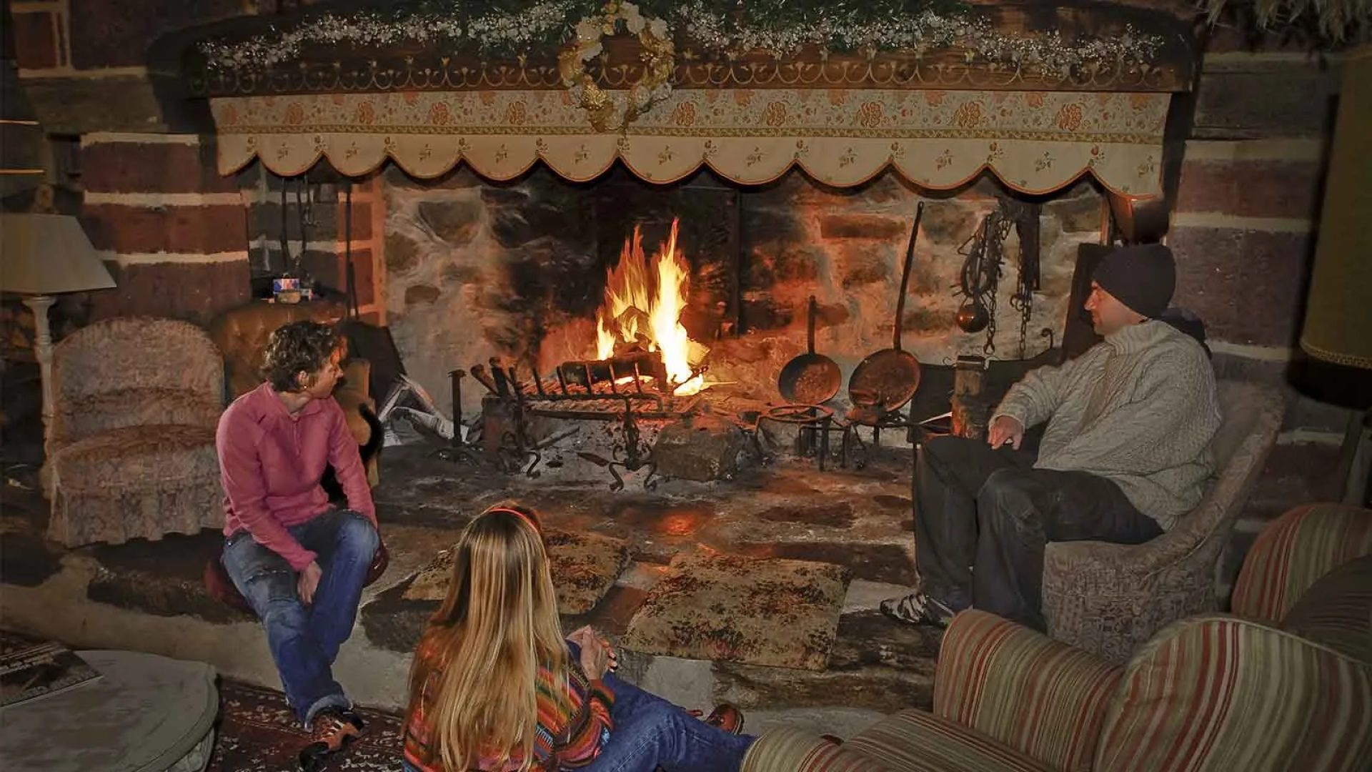 A family warms up by the fireplace in a gite in Les Estables in Haute-Loire, Auvergne