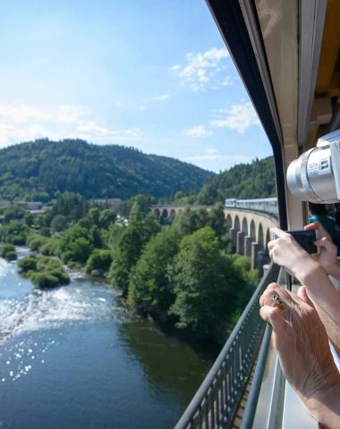 People on a train take photos of the river passing below in Haute-Loire, Auvergne