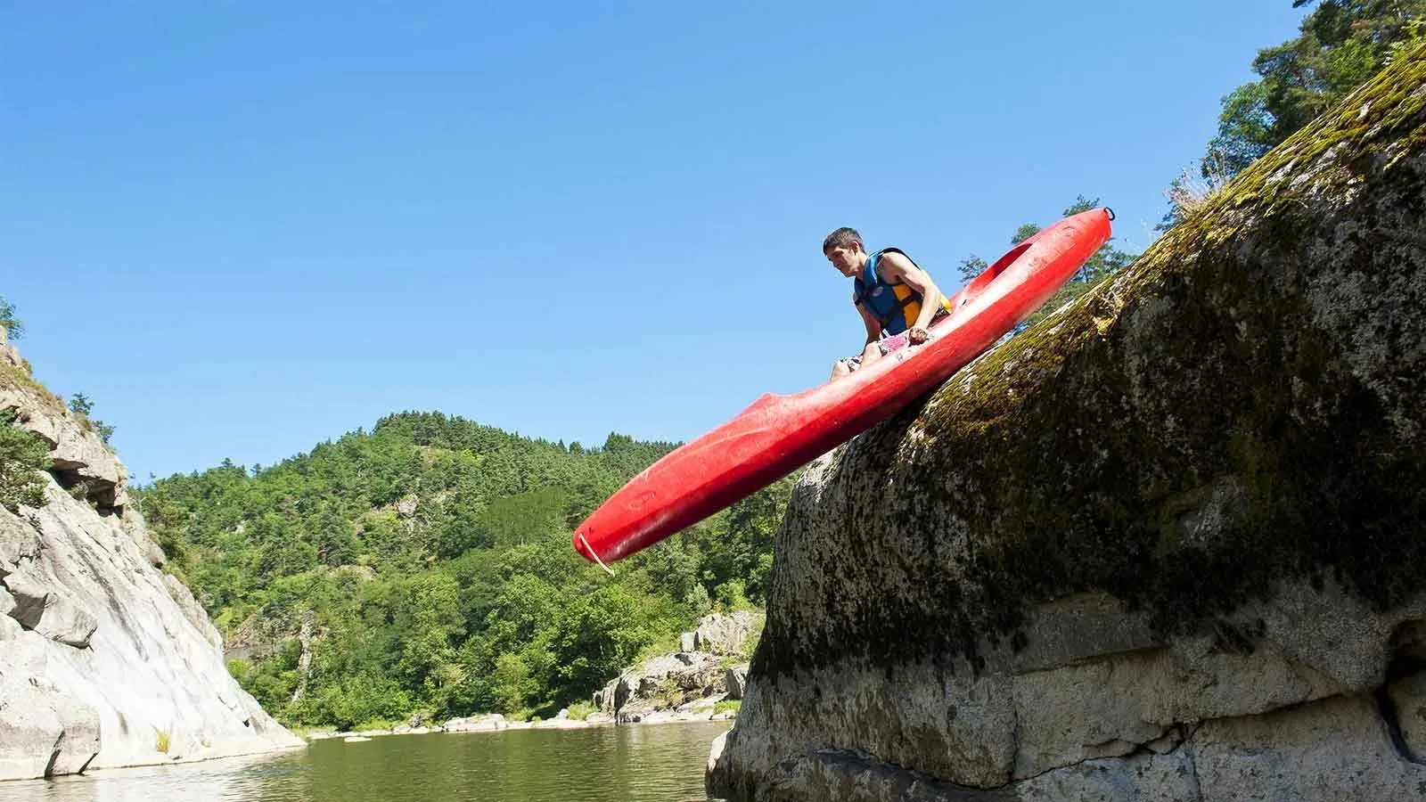 Un kayakiste glisse d'un rocher pour aller sur la rivière en Haute-Loire, Auvergne