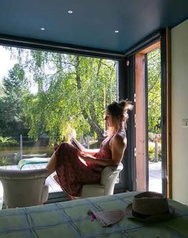 A young woman relaxes while reading a book in her guest room in Puy-en-Velay in Haute-Loire, Auvergne