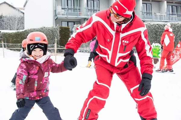Ein ESF-Alpin-Skilehrer bringt einem Kind das Skifahren im Mézenc Meygal in der Haute-Loire in der Auvergne bei