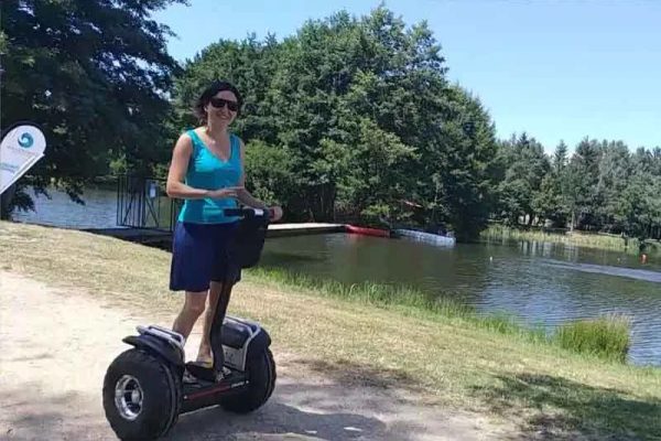 A smiling woman on a Segway next to the Saugues lake in Haute-Loire, Auvergne