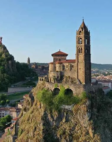 Vista del Rocher Saint-Michel d'Aiguilhe, la statua di Notre-Dame de France e il Puy-en-Velay in Haute-Loire, Auvergne