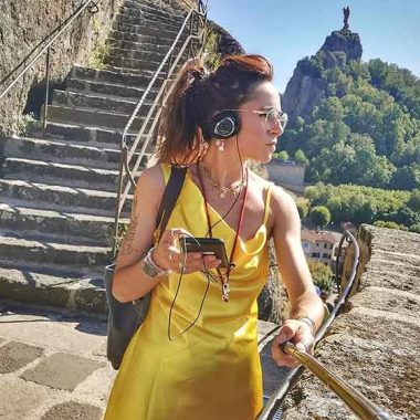 Persona escuchando la audioguía del Rocher Saint-Michel d'Aiguilhe en Haute-Loire, Auvergne