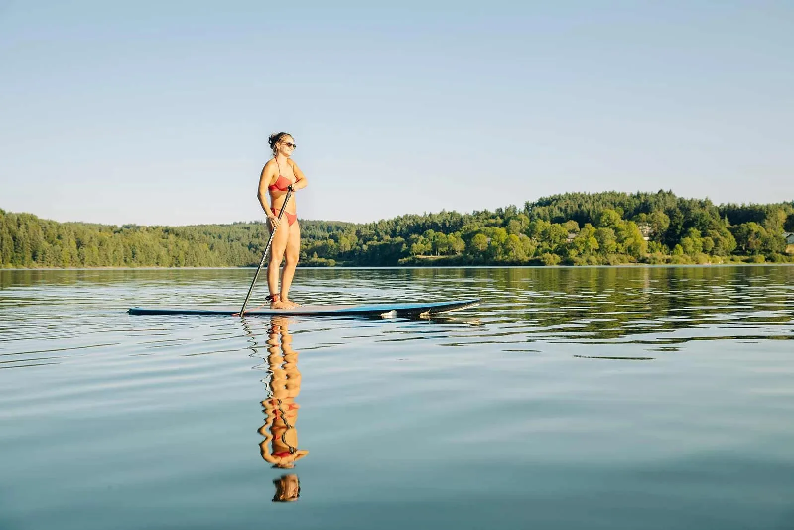 Femme sur un paddle sur le lac de Lavalette en Haute-Loire, Auvergne