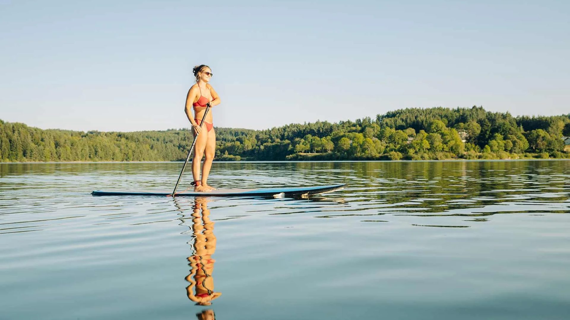 Femme sur un paddle sur le lac de Lavalette en Haute-Loire, Auvergne